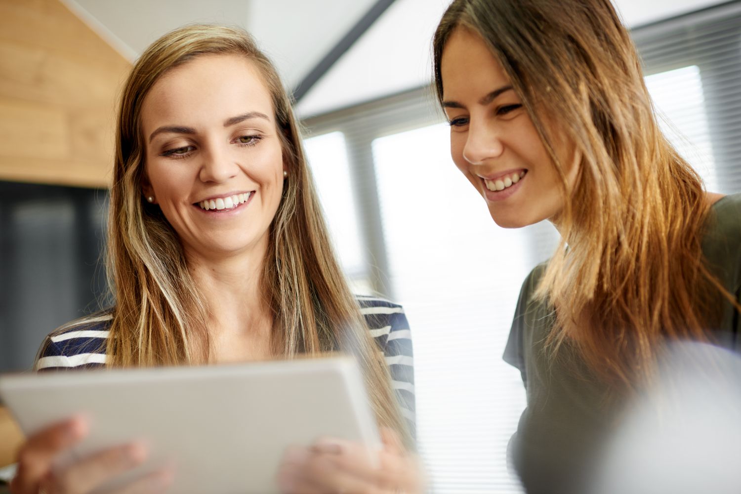 two women viewing a tablet